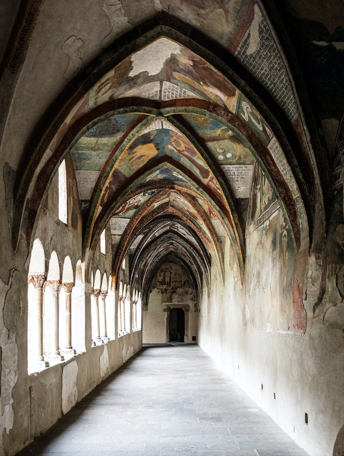 Alter Kirchengang mit historischer Malerei in Brixen